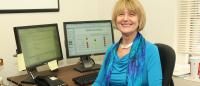 Suzanne Bakken sitting at a desk